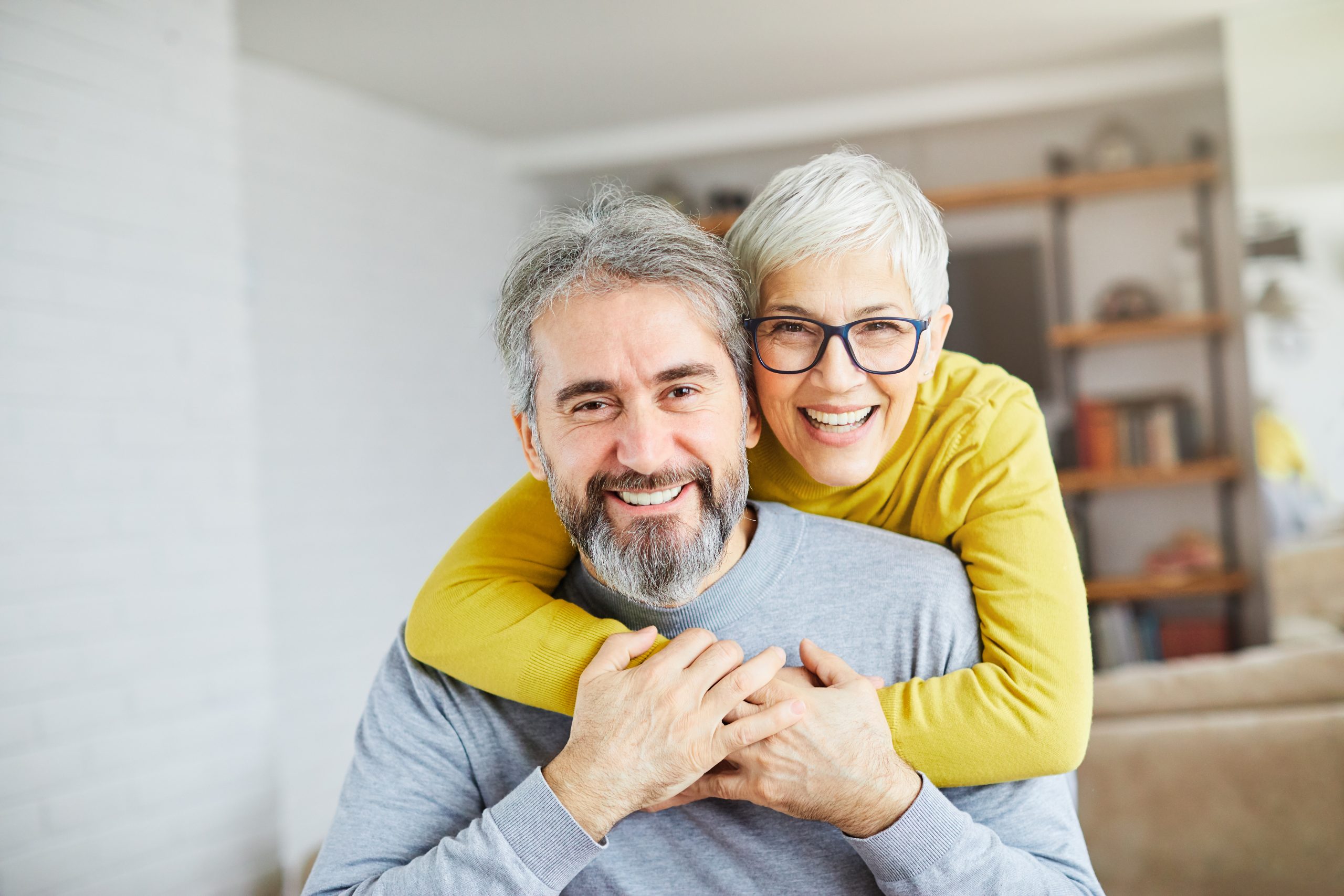 Smiling senior couple embracing at home